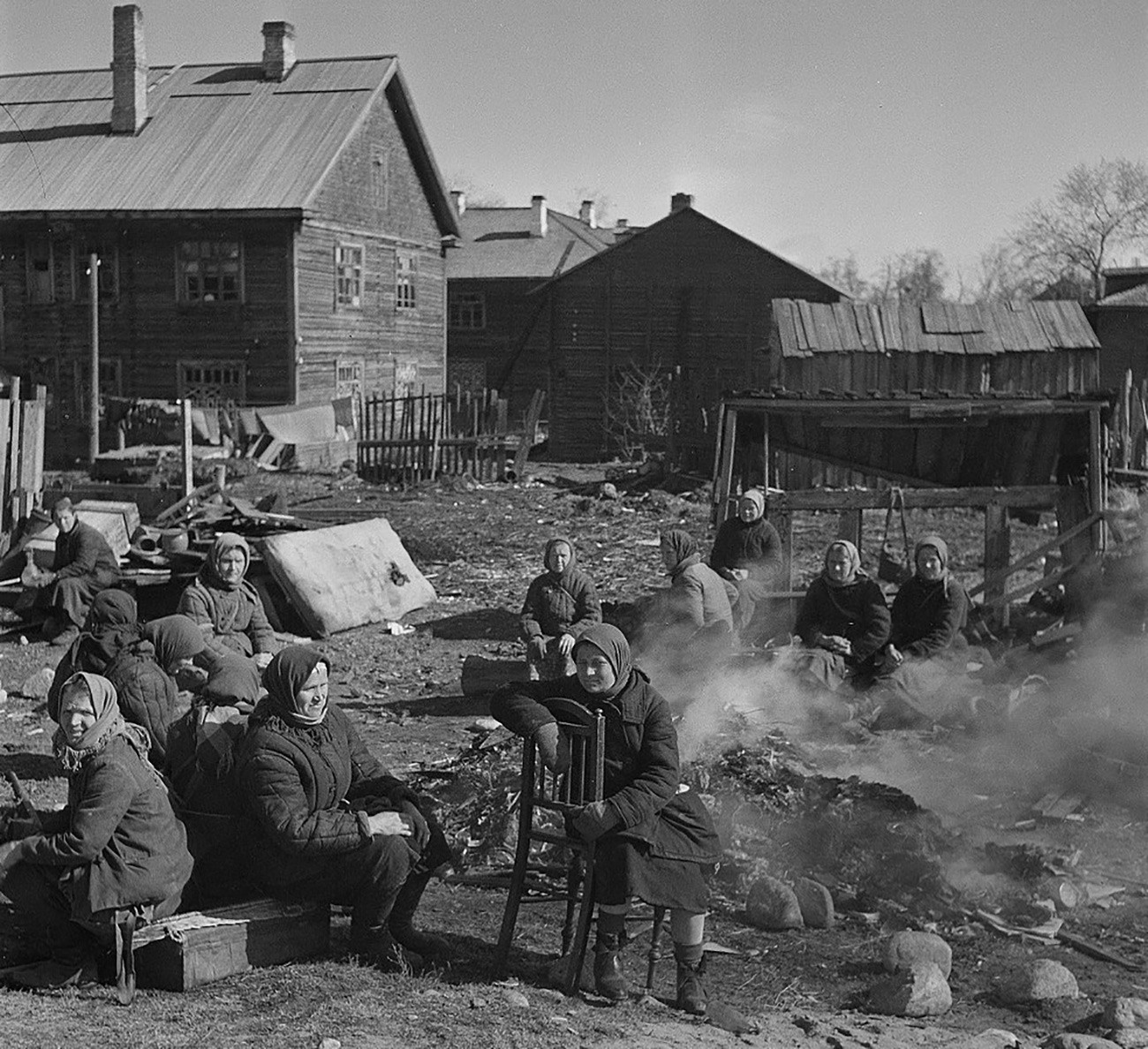 Sowjetische Frauen frühstücken neben einem brennenden Müllhaufen in einem finnischen Konzentrationslager in Petrosawodsk, Karelien.