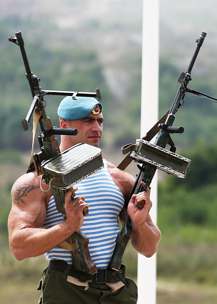 Seorang penerjun payung memegang senapan mesin saat pada pertunjukan militer dalam rangka memperingati Hari Pasukan Penerjun Paying di wilayah Krasnodar, Rusia.