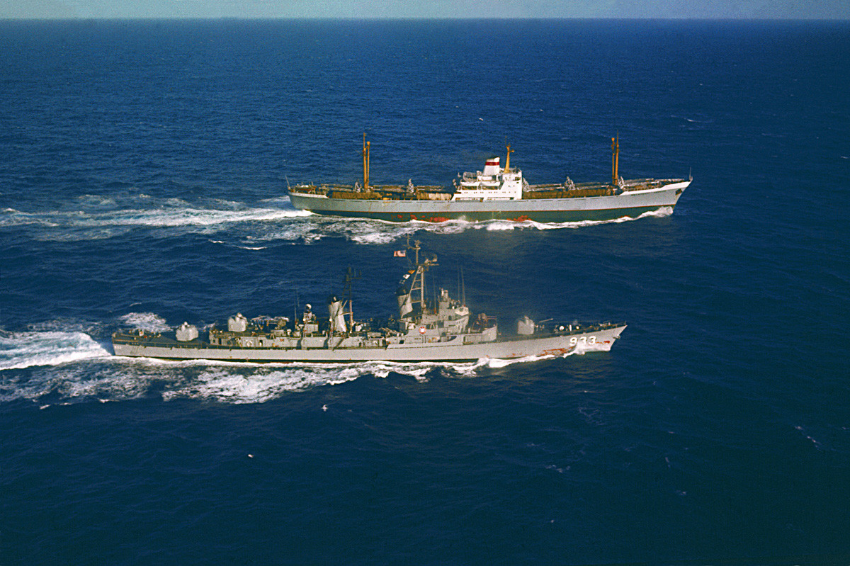 Kapal USS Barry (kiri) berlayar di sebelah kapal kargo Soviet Ansov, yang bertolak dari Kuba, untuk pemeriksaan muatan.