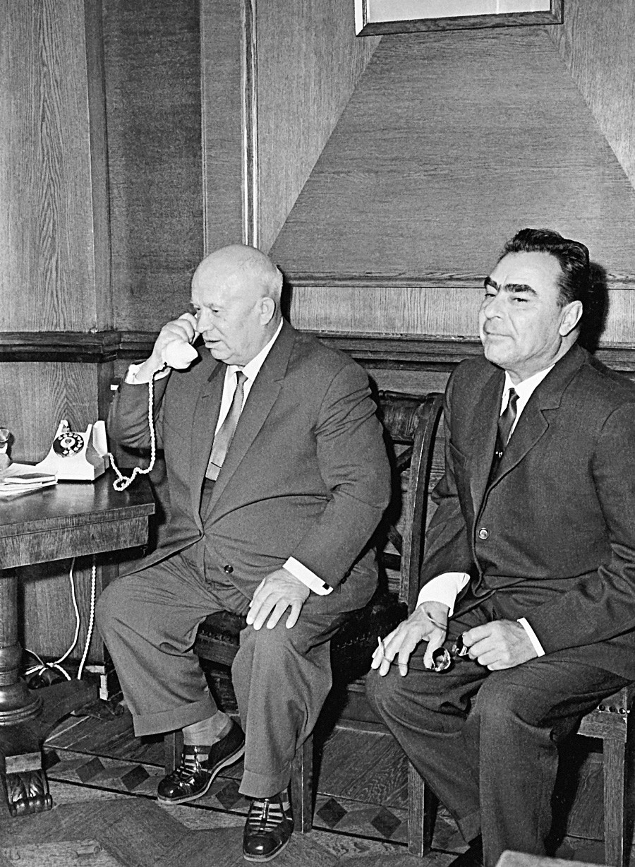 Pemimpin Soviet Nikita Khrushchev berbicara melalui telepon dengan kosmonaut Vladimir Komarov, Konstantin Feoktistov, dan Boris Yegorov yang terbang di atas pesawat antariksa Voskhod-1, 12 Oktober 1964. Pria yang duduk di sebelahnya adalah Leonid Brezhnev.