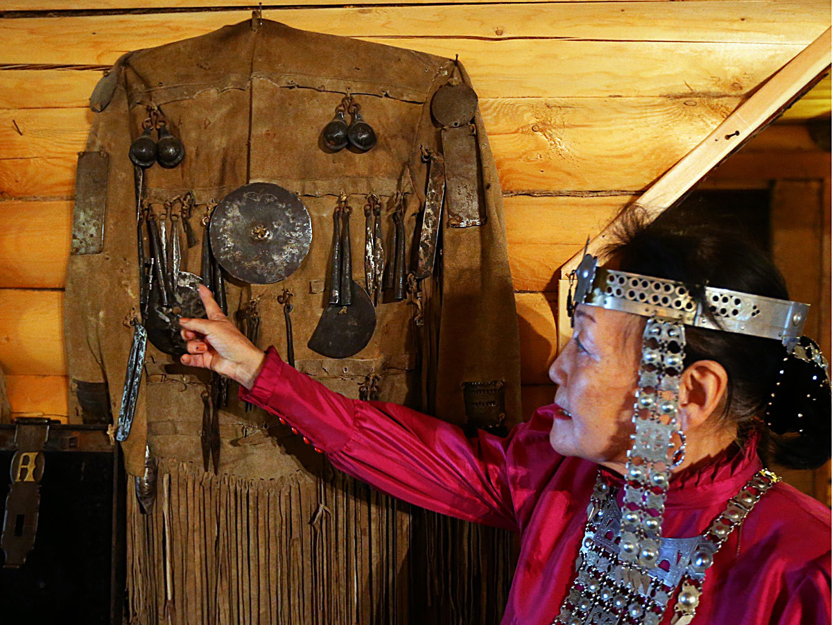 Valentina Atlasova u jakutskoj narodnoj nošnji prikazuje restauriranu šamansku nošnju u Us-Kutu, domaćinstvu obitelji Atlasov.