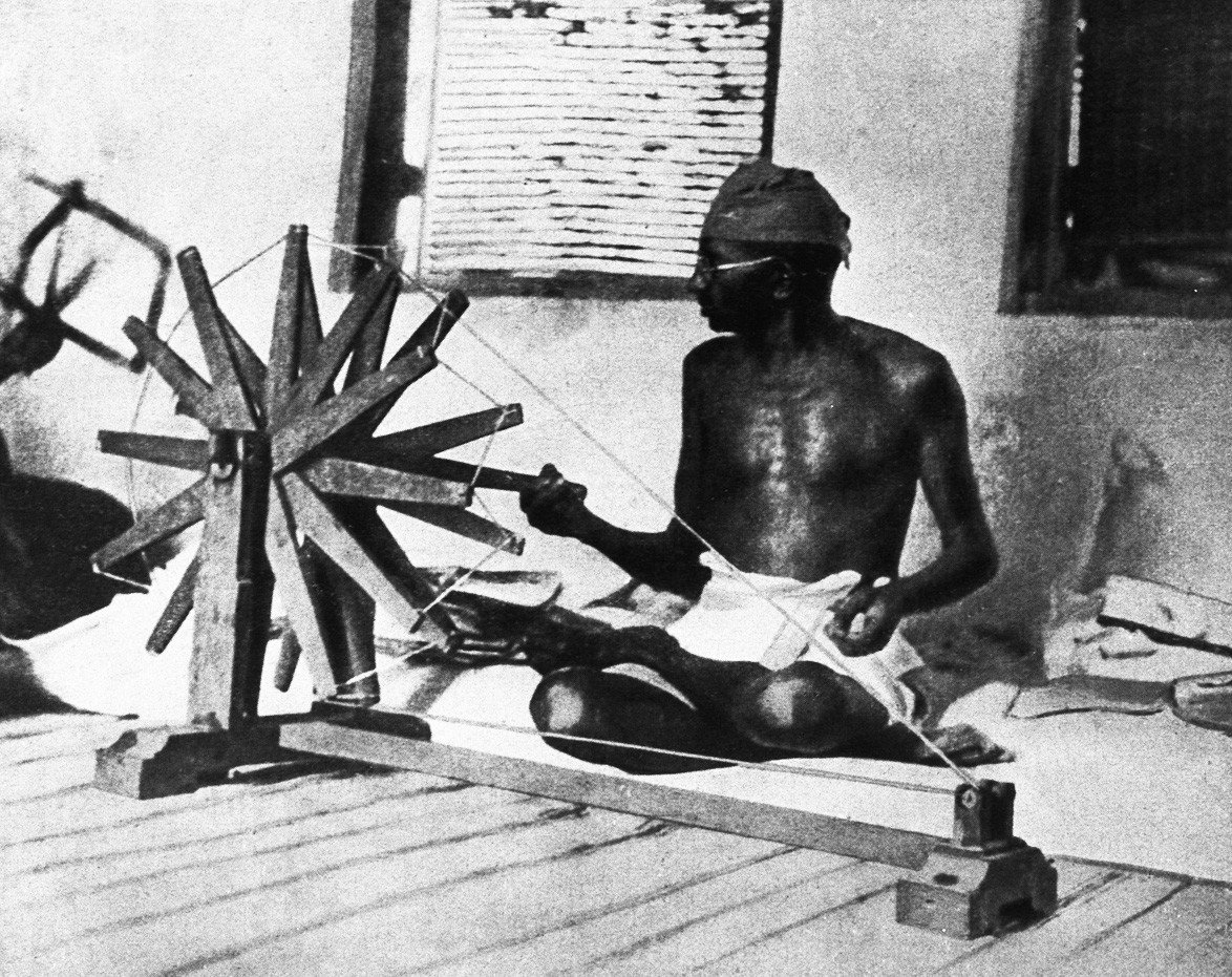 Mahatma Gandhi memutar penggulung kapas, India, 1910.