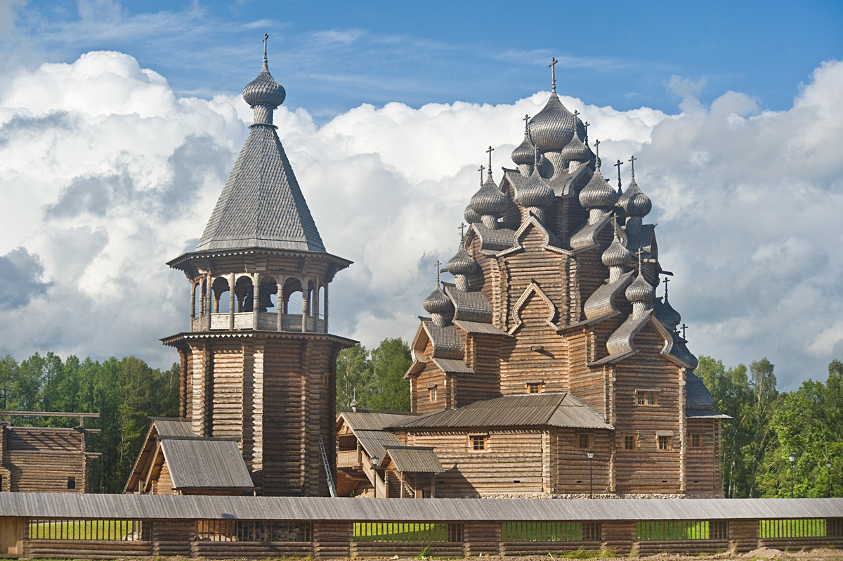 Bogoslovka. Church of the Intercession. Southwest view with reconstructed log bell tower (1670s, originally from Lower Uftyuga village). August 17, 2009.