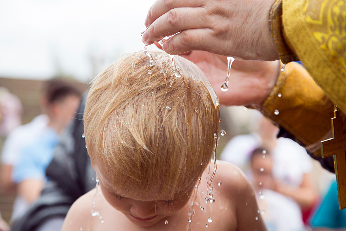 A little participant of the mass baptism ceremony