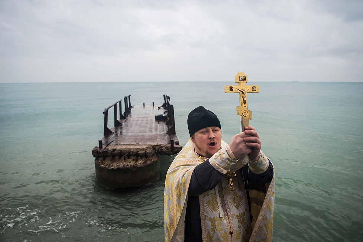 A priest conducts the blessing of the water in the Black Sea in Sochi's Khotinsky District