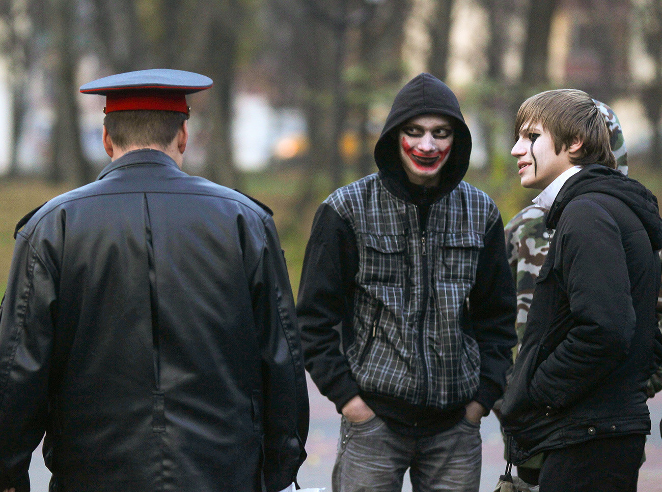 Un membre des forces de l'ordre passe devant des jeunes déguisés à Novgorod.