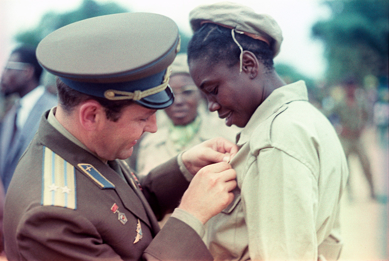 Guerman Titov, pilote-cosmonaute soviétique, deuxième homme dans l'espace et héros de l'URSS,  remet une insigne à une jeune Congolaise lors de sa visite en République démocratique du Congo.