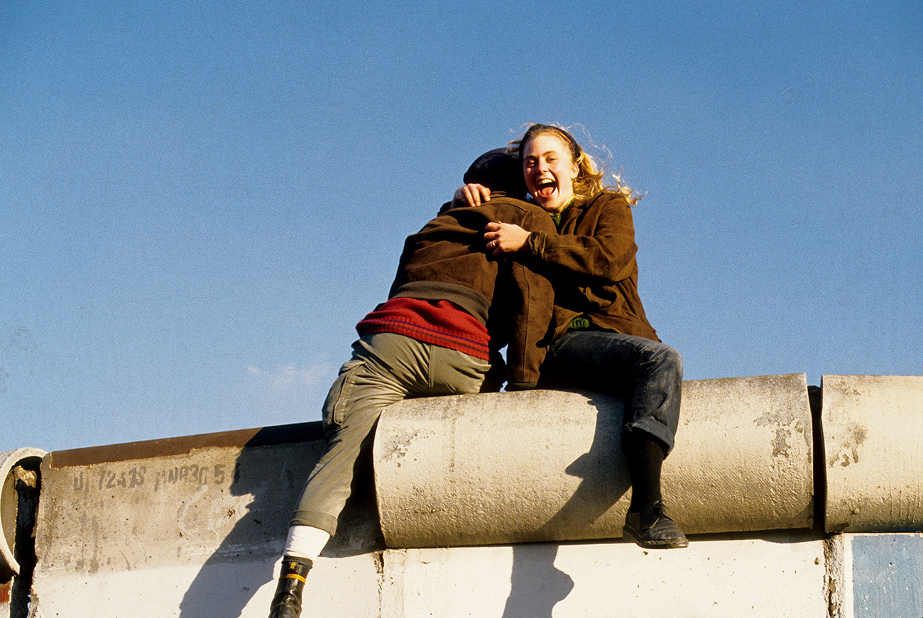 Германия Берлин (Запад) Тиргартен - отваряне на стената: влюбена двойка, седнала на стената
