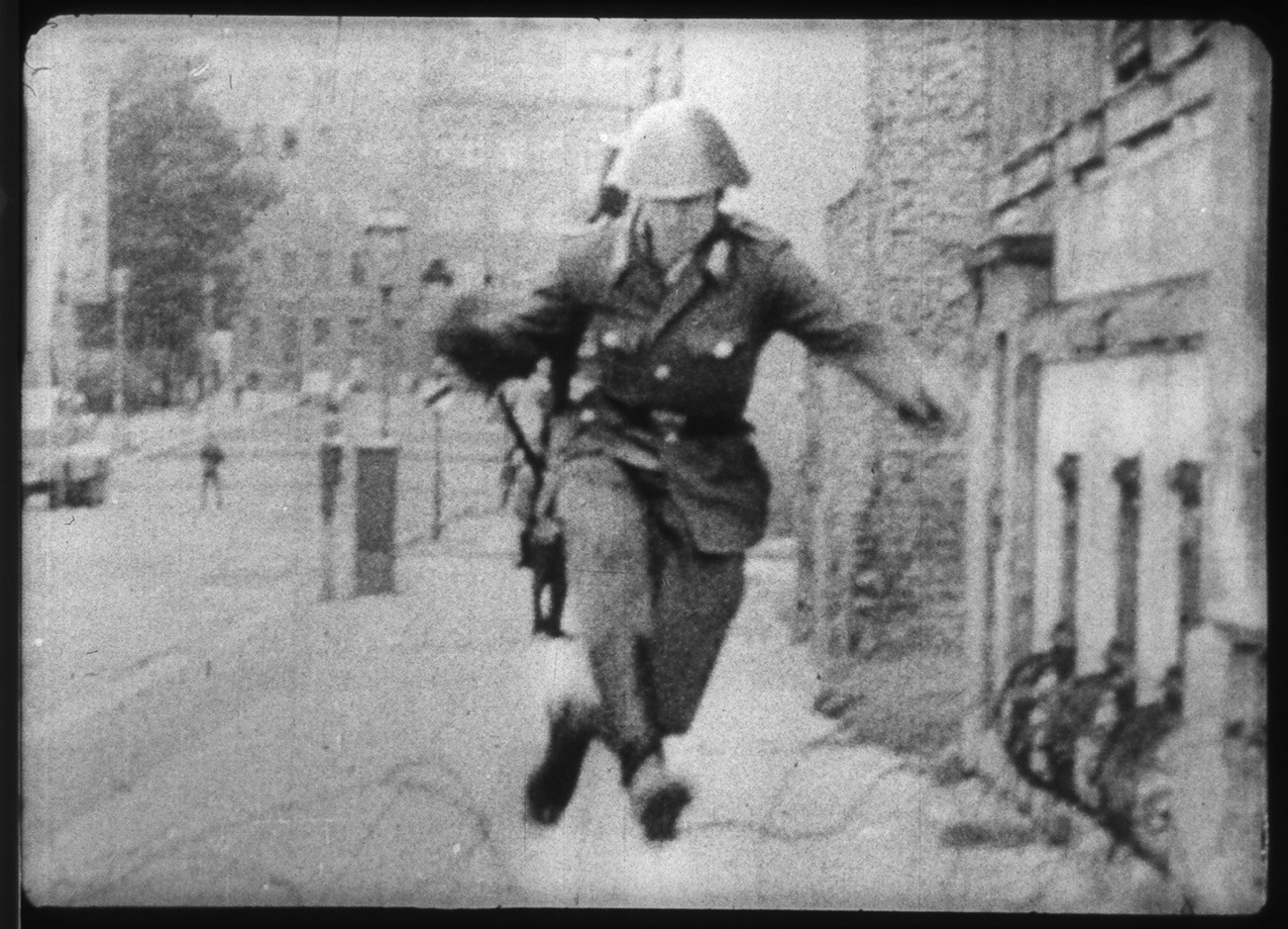 Источнонемачки полицајац Конрад Шуман прескаче бодљикаву жицу.