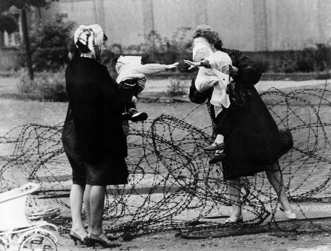 Ibu dengan anak dipisahkan oleh kawat berduri di Berlin, Agustus 1961.