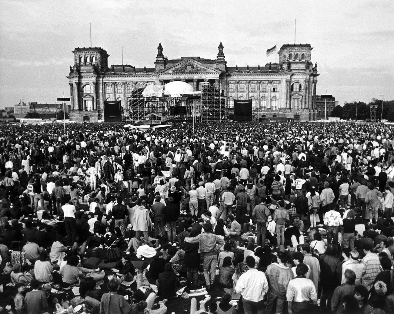 Orang-orang berkumpul saat menonton konser musisi Inggris David Bowie di depan gedung Reichstag, Berlin Barat , 6 Juni 1987. 