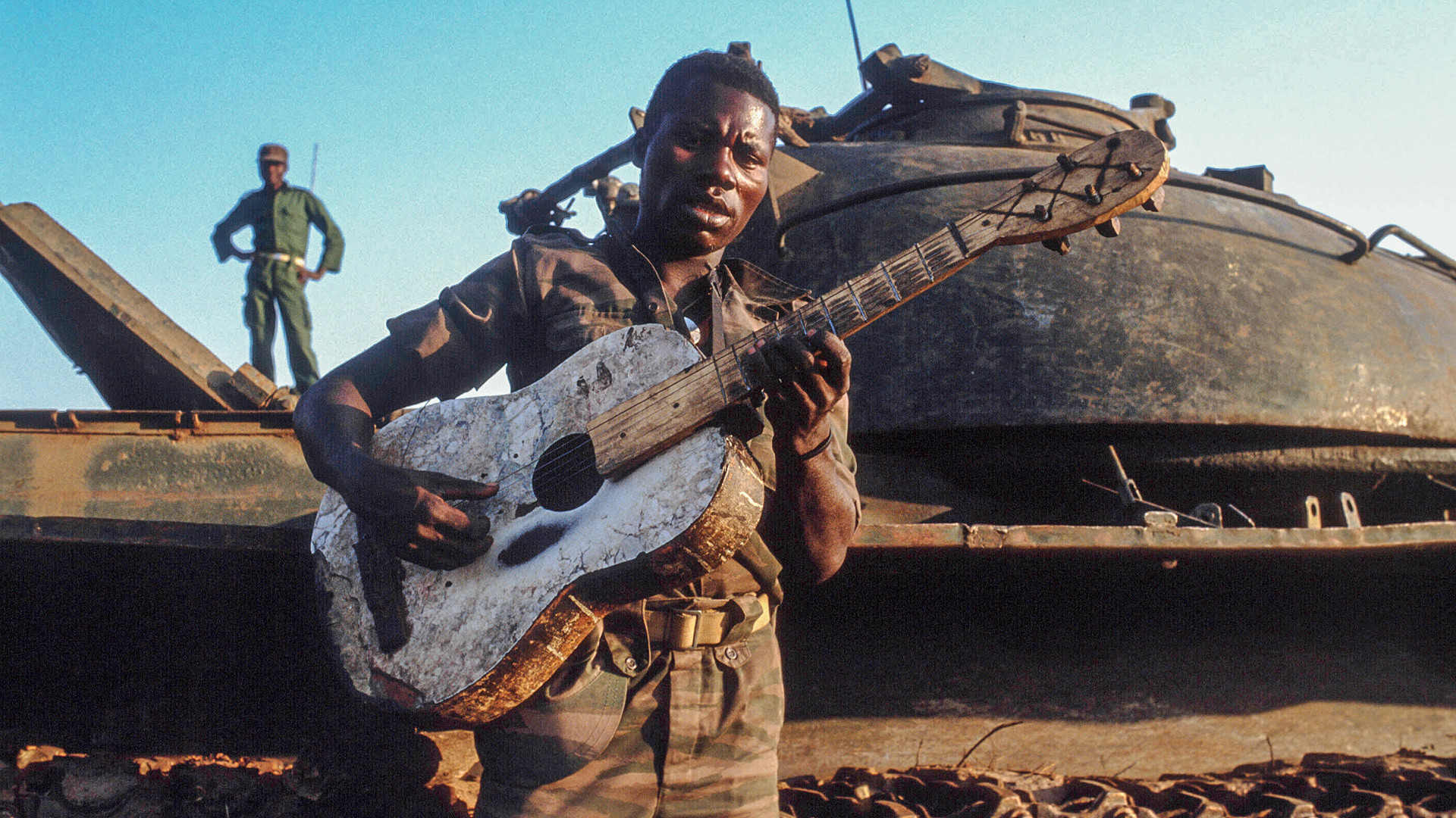 Ein afrikanischer Soldat mit einem sowjetischen Panzer T-34 im Hintergrund