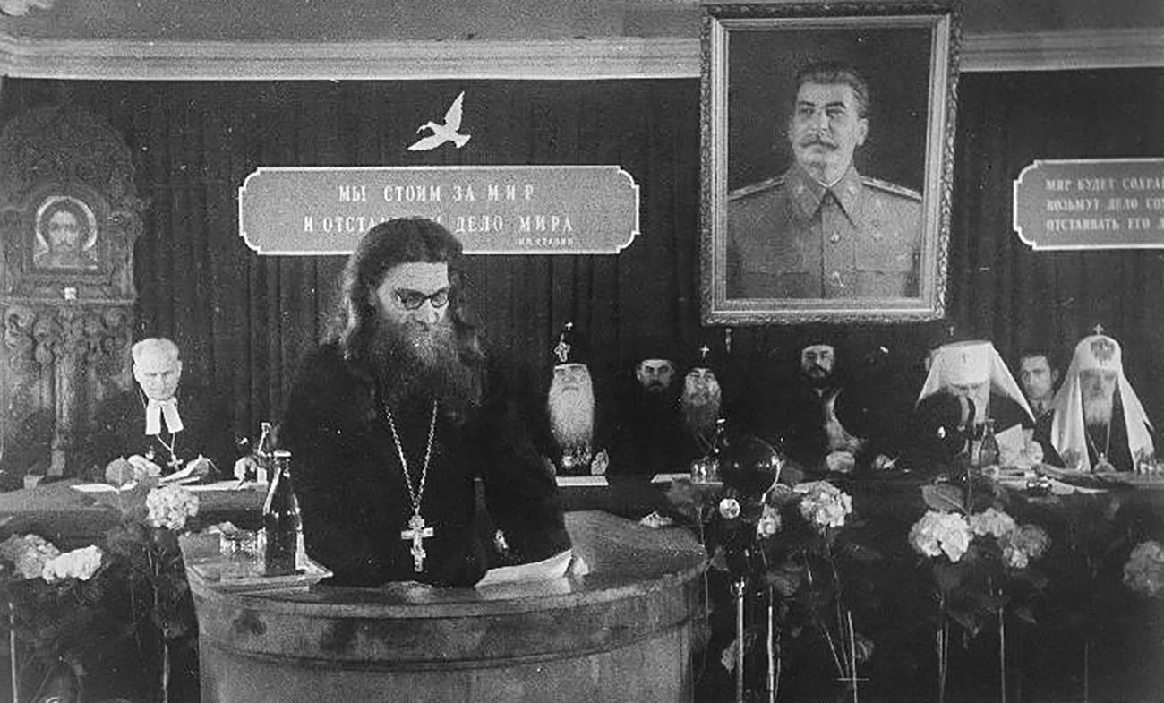 Seorang pendeta memimpin rapat di bawah potret Stalin, 1940-an.