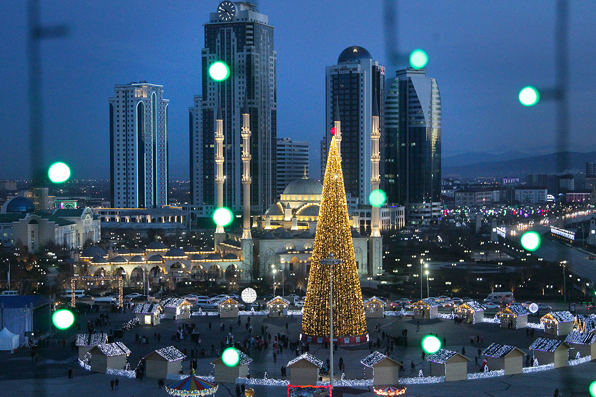 Новогодишните светлини на коледното дърво и небостъргачите в центъра на Грозни, столицата на Чечня.
