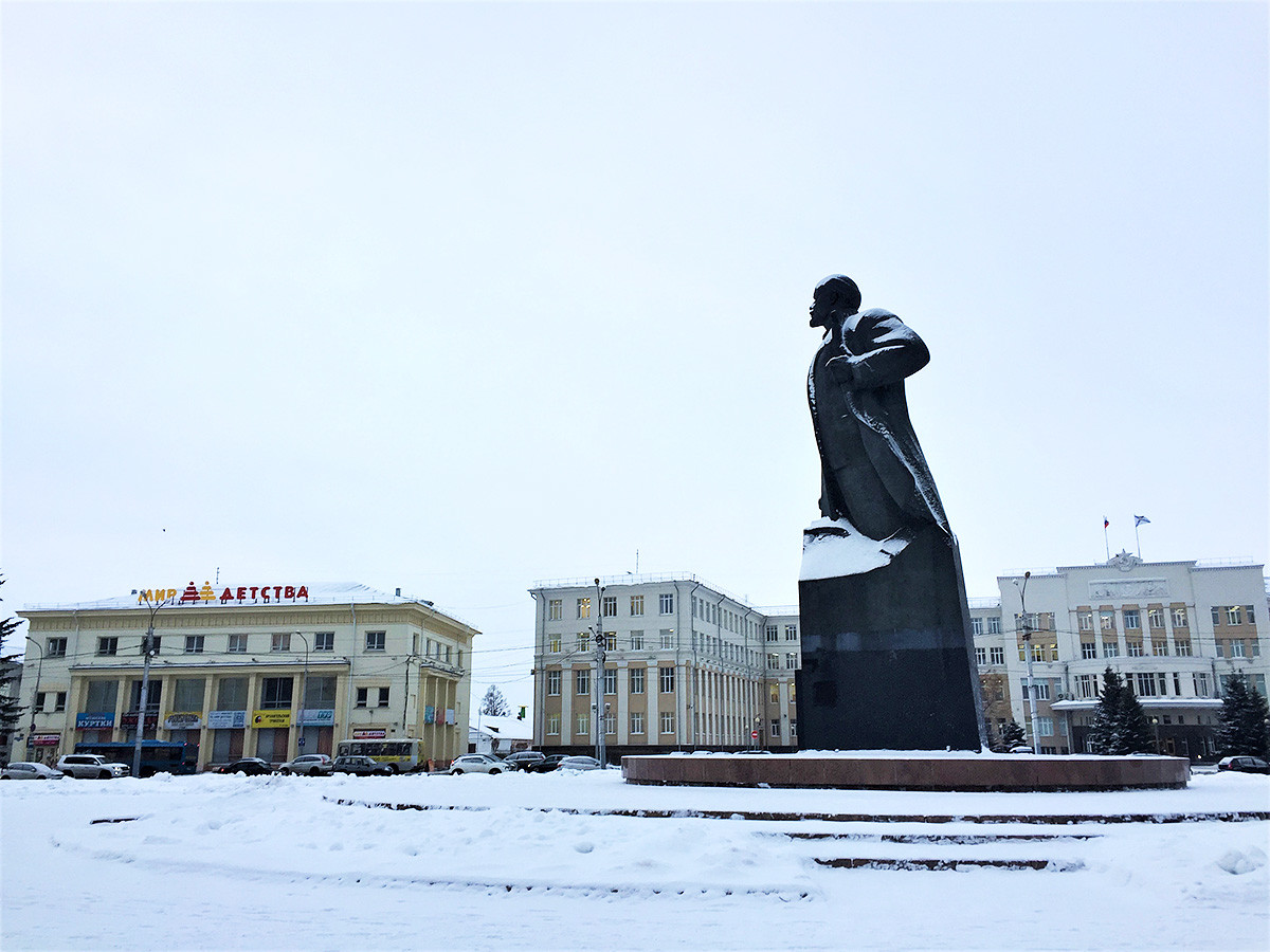 Statue to Vladimir Lenin on the main city square. Sign on the left reads 
