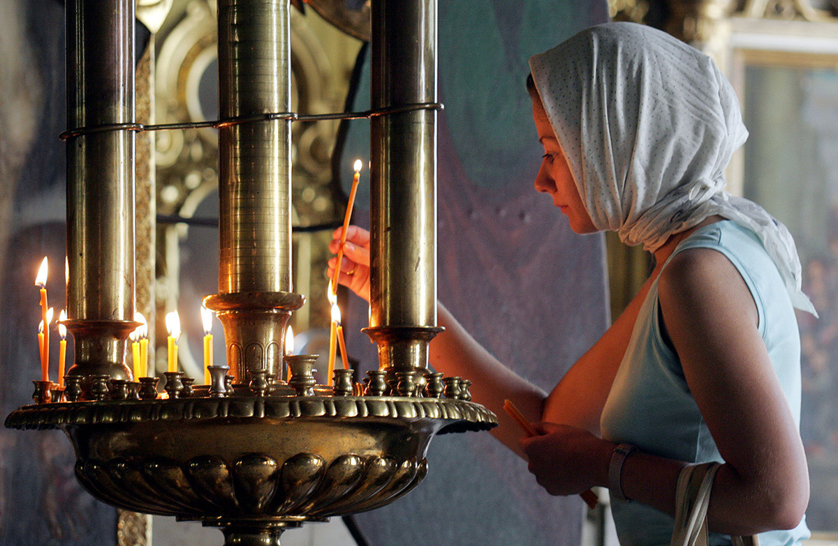 Rusinja prižiga svečo med spominsko mašo v Moskvi