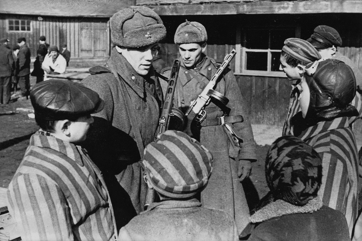 Soviet Army soldiers chatting to the children just liberated from the Auschwitz concentration camp 