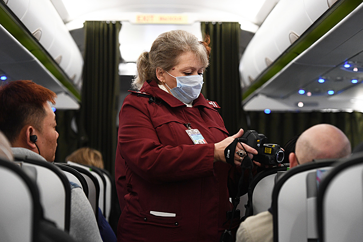 A worker of quarantine and sanitary station checks the temperature of passengers arrived from Bejing on board a plane at airport in Novosibirsk, Russia. Russian airports have stepped up screening of travelers arriving from China to try to identify people infected with the new coronavirus. 