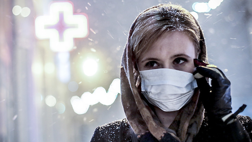 Rusia. Novosibirsk. 28 de enero. Una mujer con una máscara médica en una de las calles de la ciudad. 