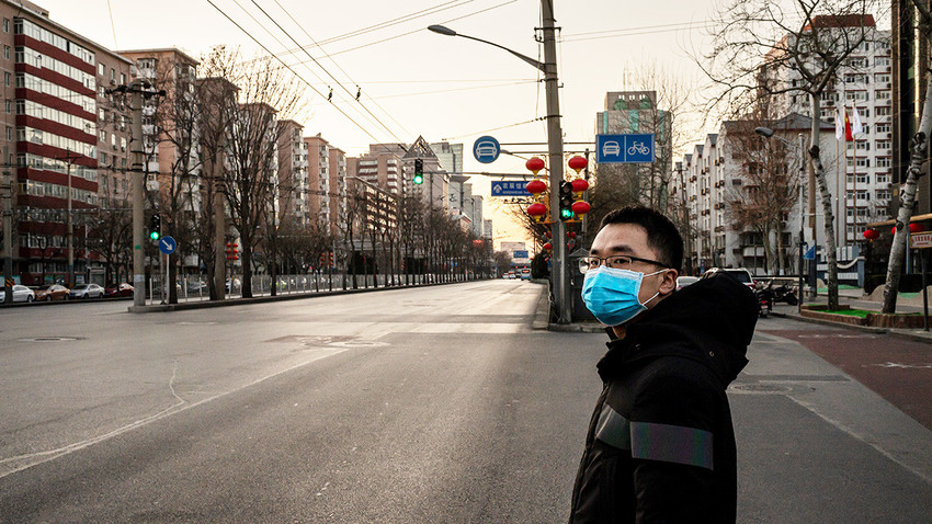 Ilustrasi: Seorang warga Tiongkok berdiri di jalanan yang sepi di Kota Beijing, baru-baru ini.