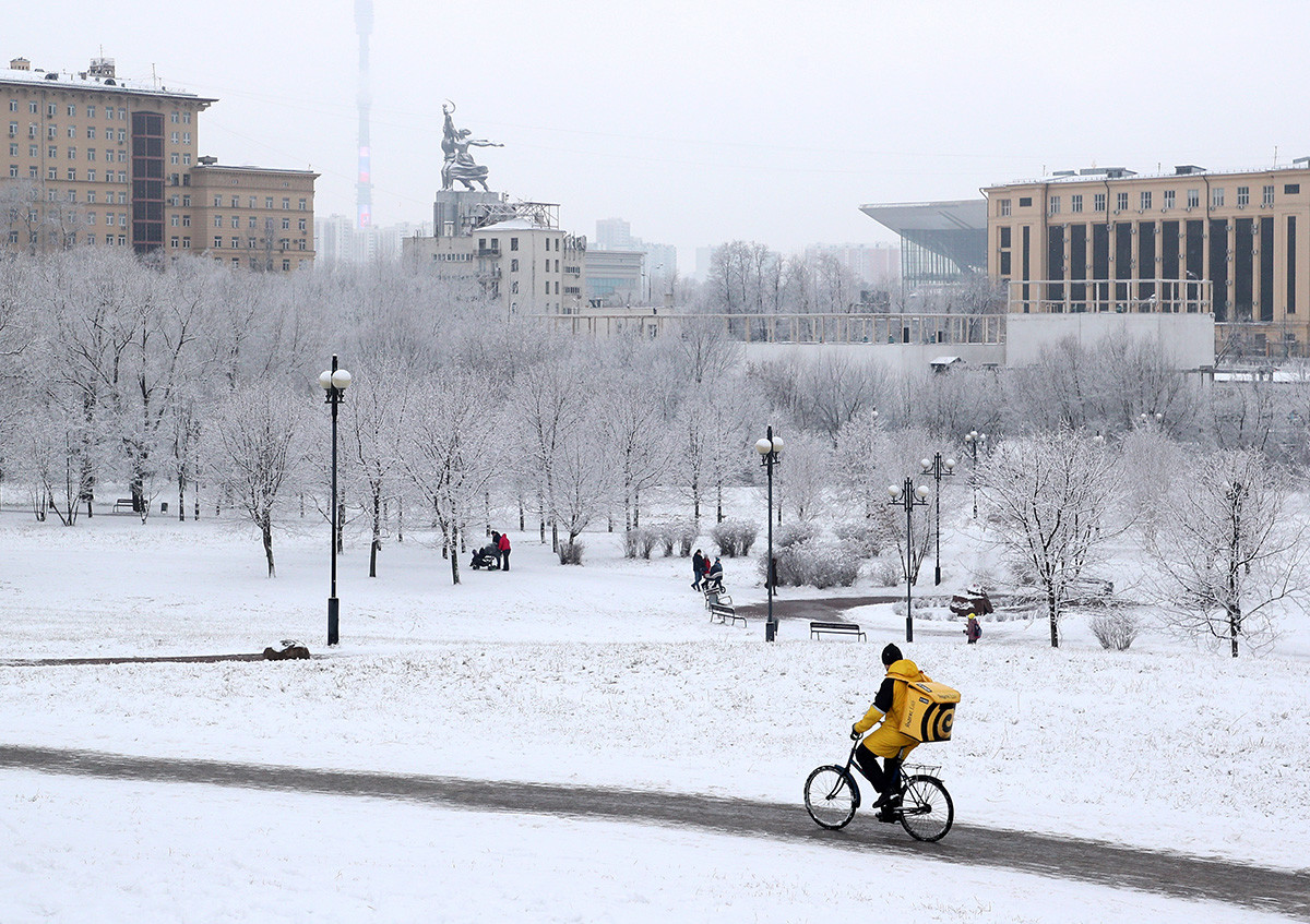 Курир сервиса „Яндекс.Еда“ на бициклу у парку близу Ростокинског акведукта