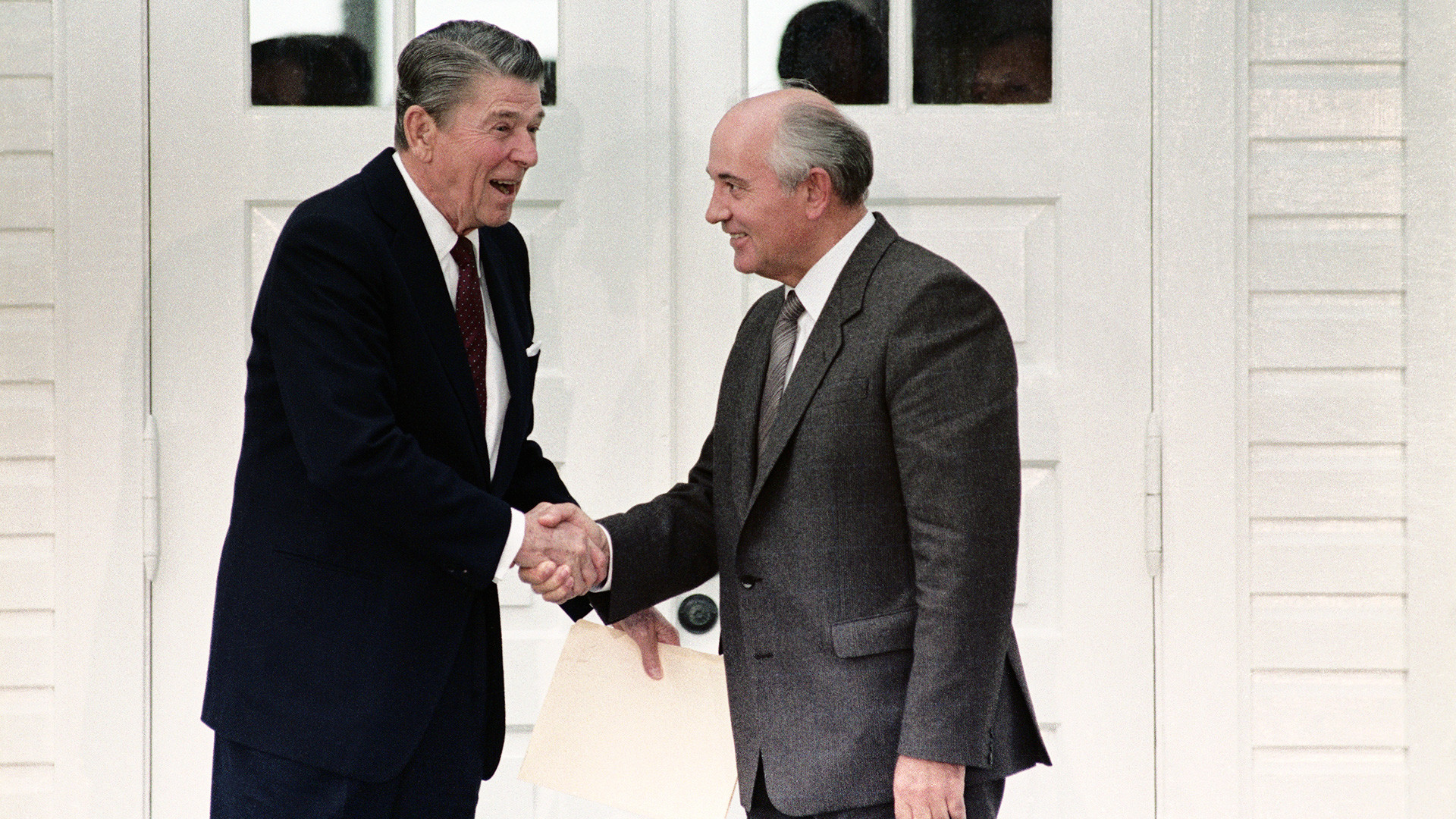 Concluant une rencontre matinale, le président américain Ronald Reagan et le secrétaire général soviétique Mikhaïl Gorbatchev se serrent la main.