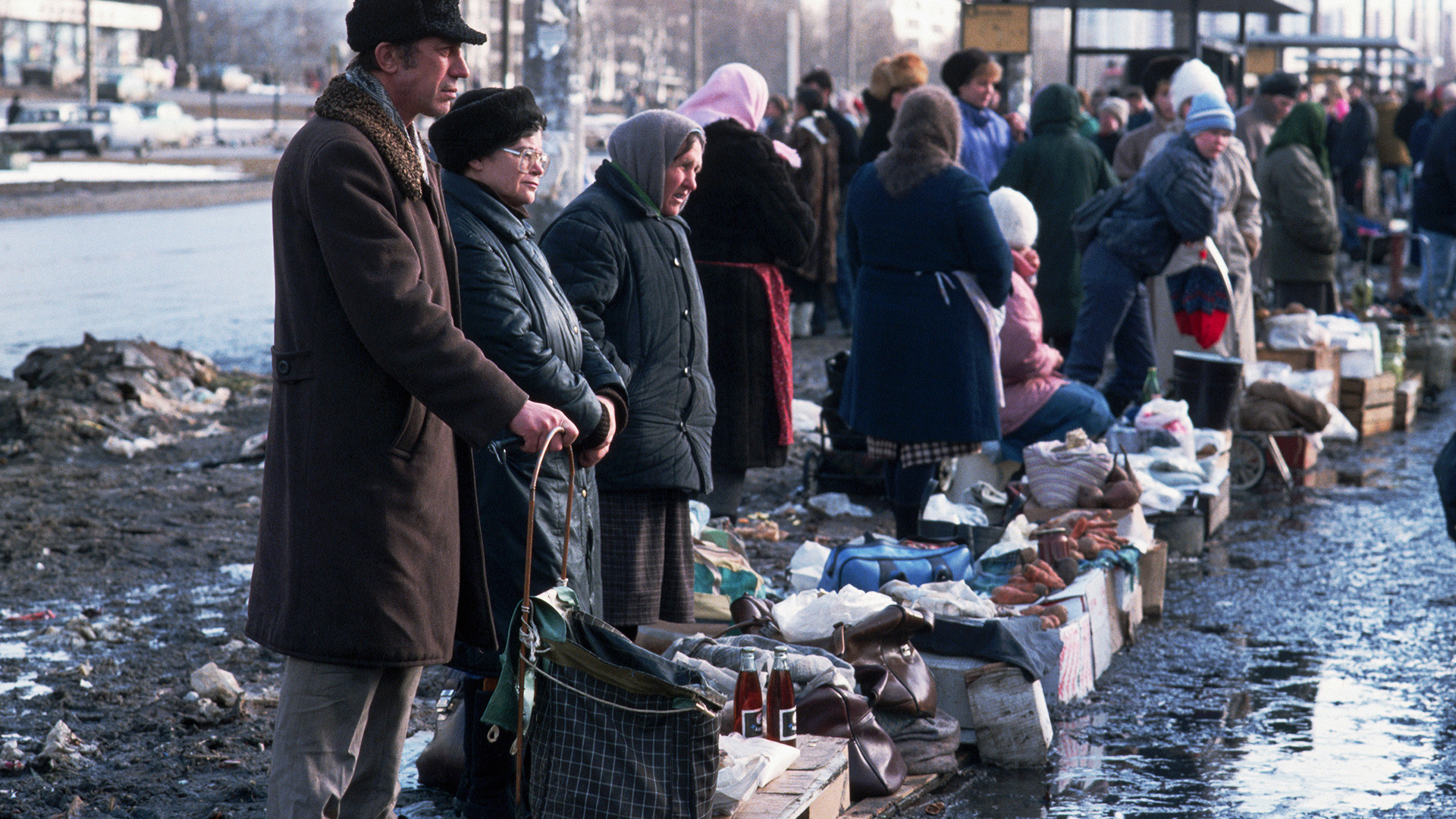 Des citoyens vendent leurs biens sur un marché installé le long d'une rue boueuse de Moscou.