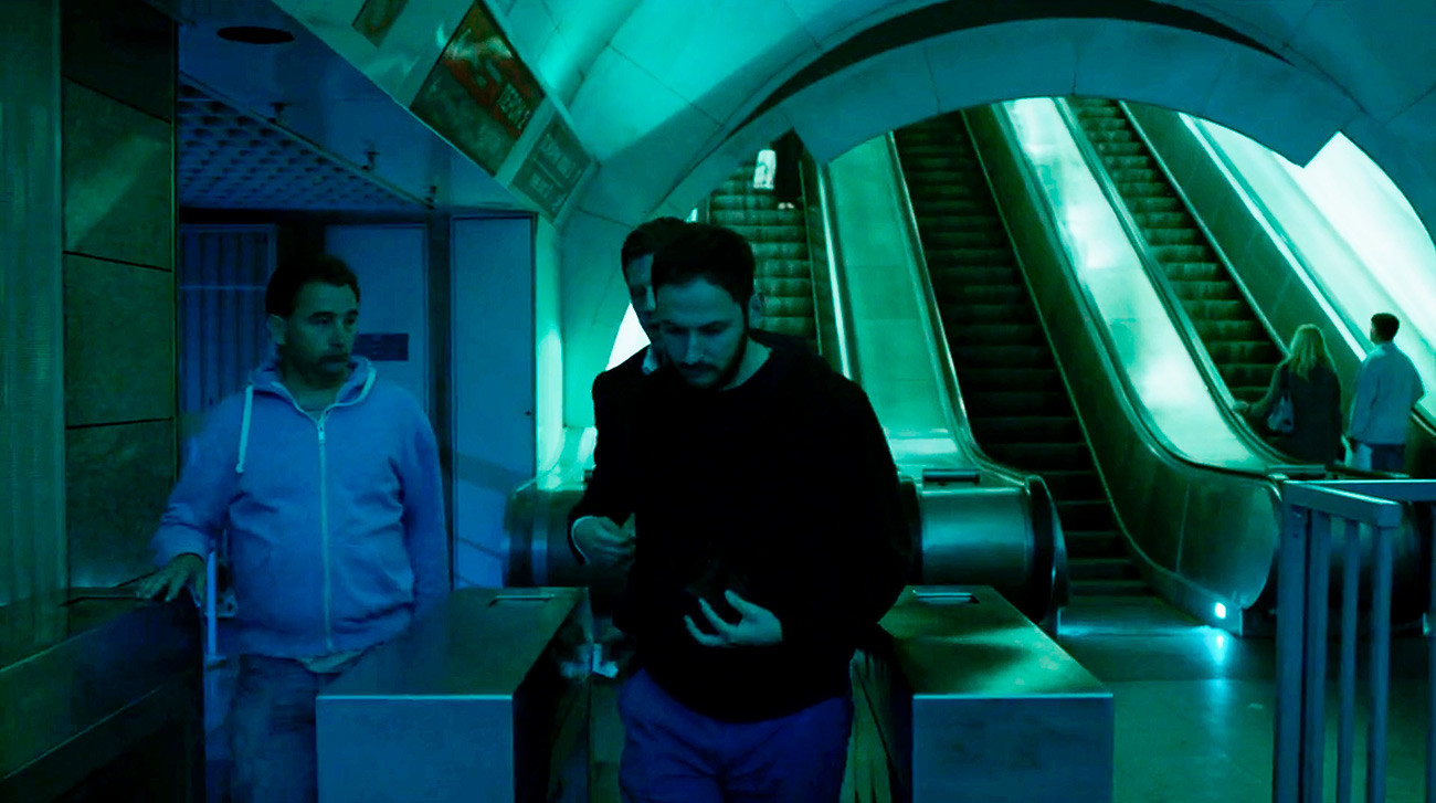 Alex se u metrou kroz rampu progura iza drugog putnika.