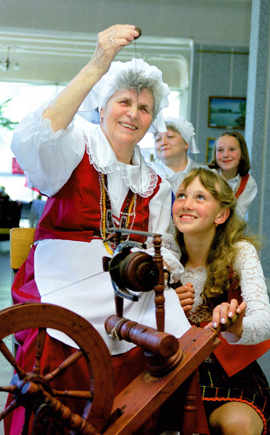 Lidia Mertes (a la izquierda) de Ekibastus le muestra a Alena Schmidt cómo usar una vieja rueca