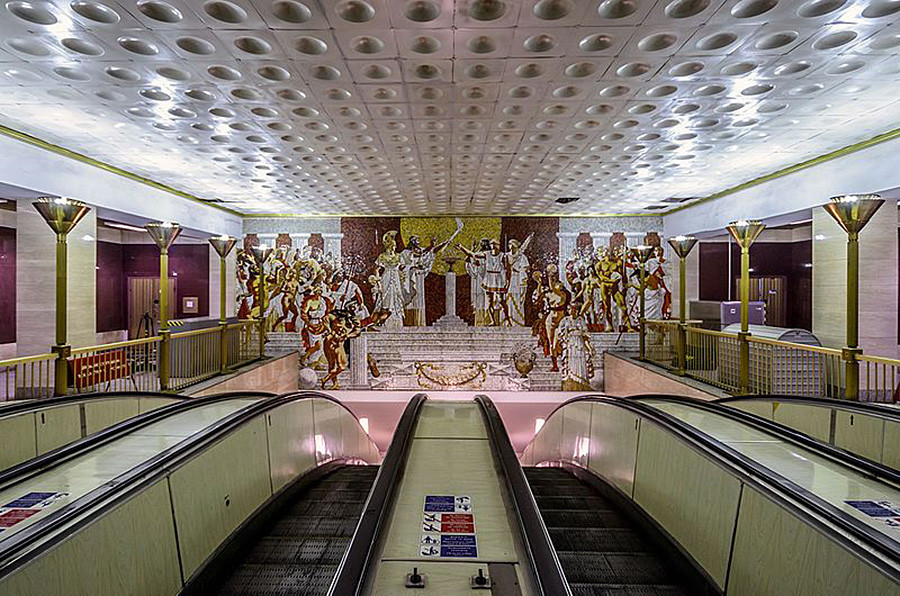 Hall superior da estação Sportívnaia decorado com atletas e deuses gregos.