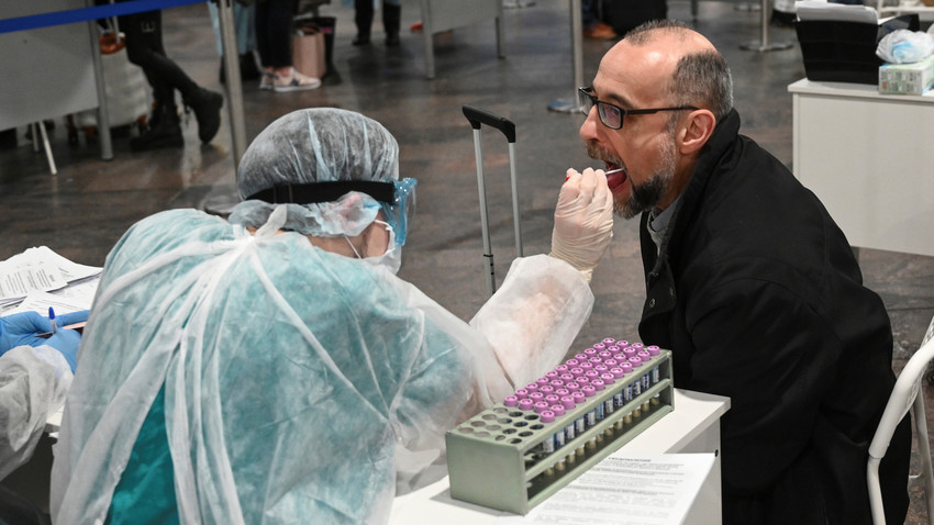 A medical worker checks passengers at Moscow's Sheremetyevo Airport.