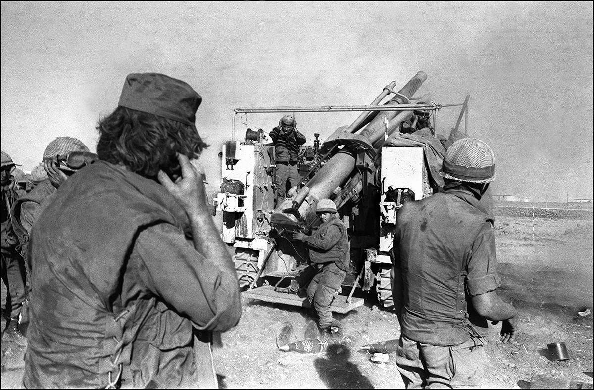 Israeli soldiers plug their ears as they fire shells from a French-made 155mm Howitzer gun at the Syrian lines on the Syrian Golan Heights, two weeks after the beginning of the Yom Kippur War, 17 October 1973.