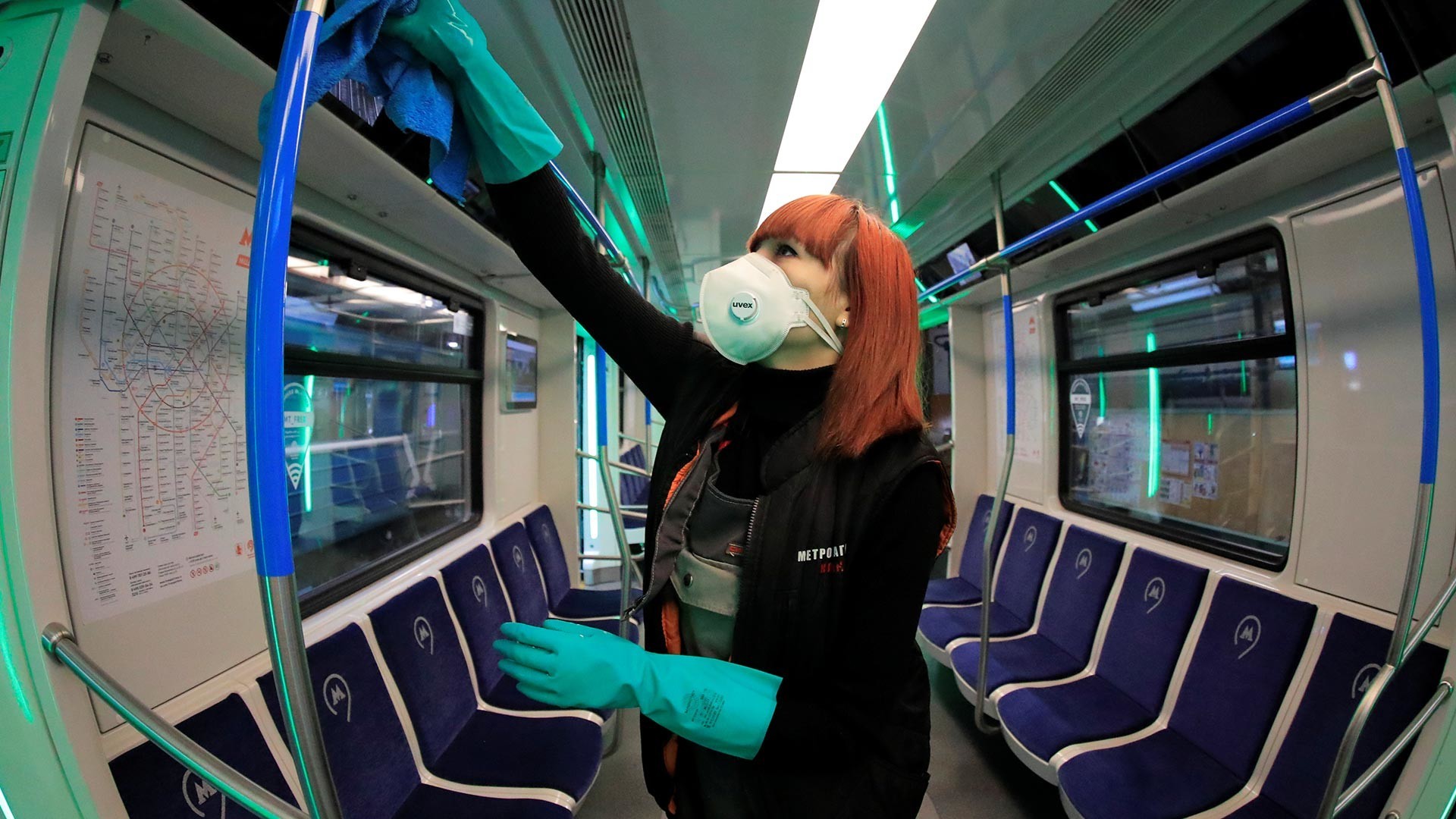 Delavka iz masko čisti in razkužuje vlak v moskovski podzemni železnici