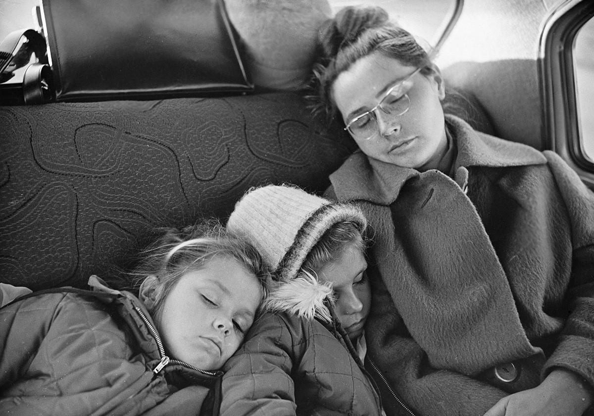 Yuri Gagarin's wife Valentina (right) with the daughters sleeping on the back seat on November 25, 1965.