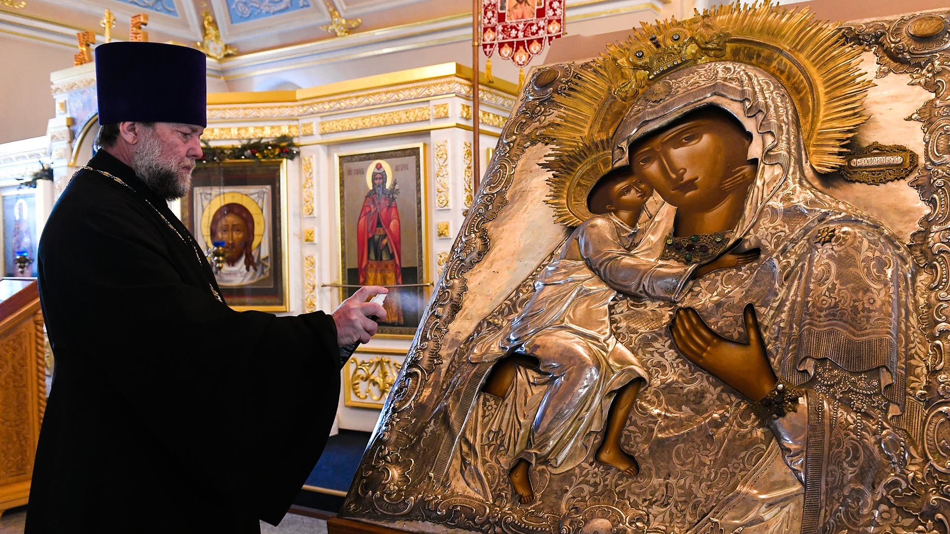 The rector of the Church, priest Vladimir Dukhovich during the sanitary treatment of the icon in the Church of St. Alexy in Rogozhskaya Sloboda