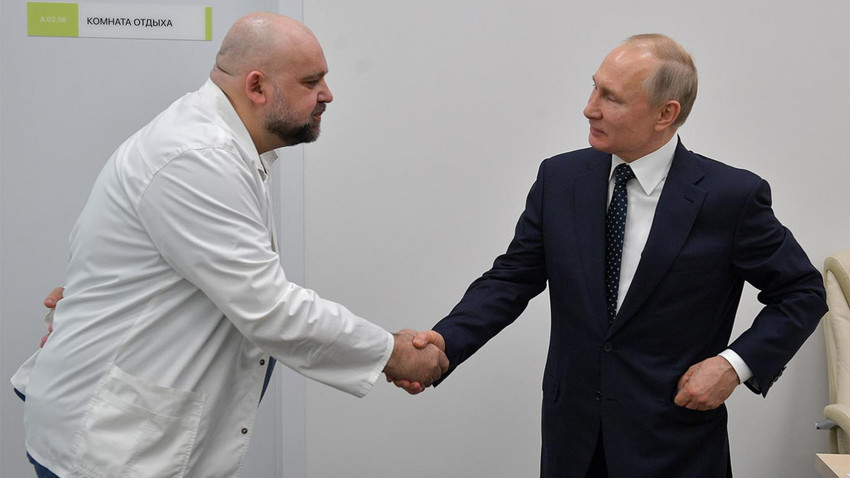Kepala Dokter Rumah Sakit Kota No.40 Denis Protsenko berjabat tangan dengan Presiden Vladimir Putin seusai meninjau rumah sakit, Senin (24/3).