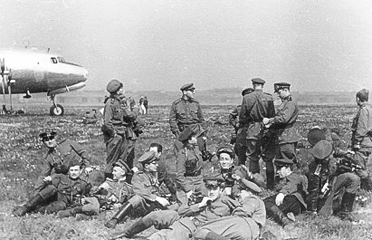 イリヤ・アロンス。ドイツの降伏文書に署名するためにやって来る連合国司令官らを待つ戦場カメラマンら。ベルリンのテンペルホーフ空港にて。1945年5月8日。