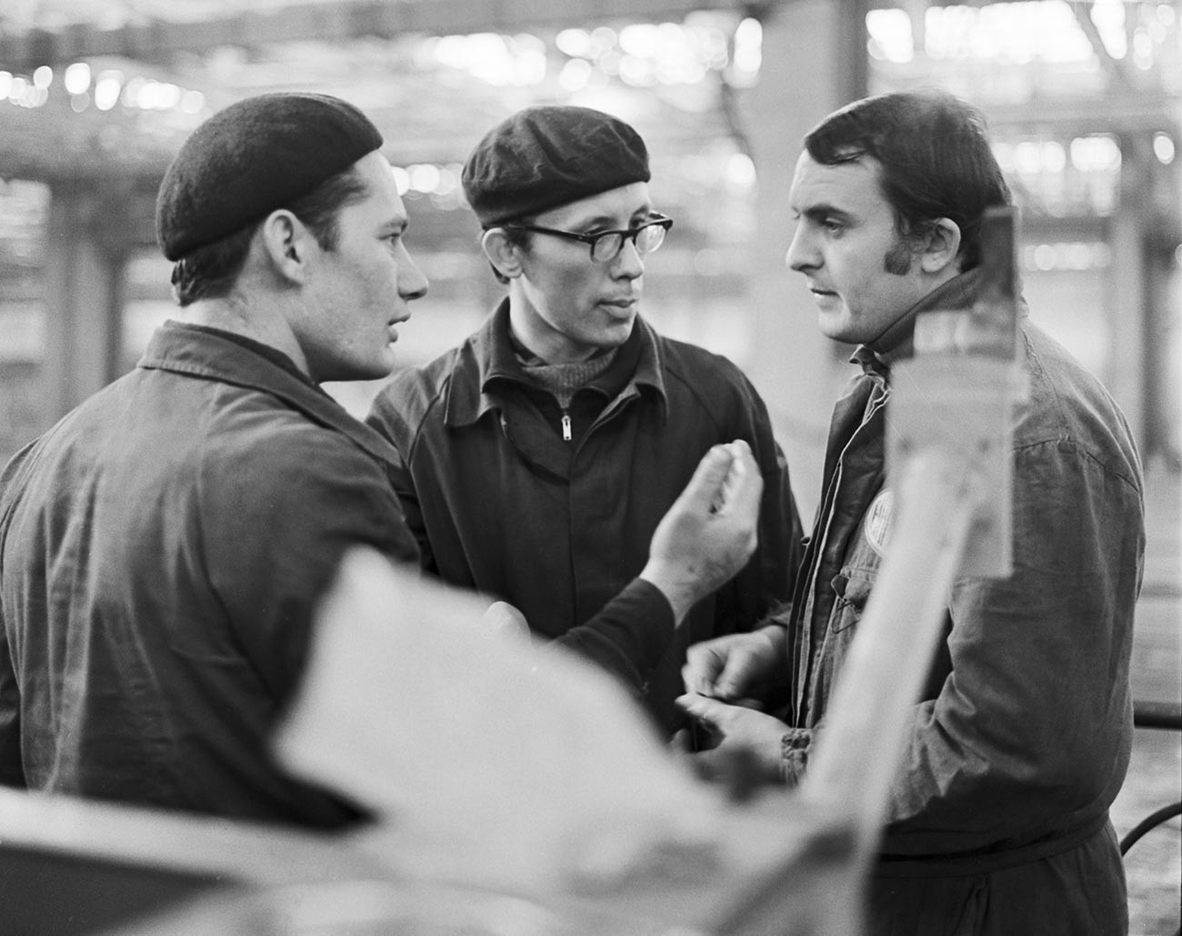 V hali za varjenje ogrodja tovarne VAZ; sovjetska specialista Sergej Jasinski in Nikolaj Borodin se pogovarjata z italijanskim specialistom Vittoriom Benagijem (z leve proti desni)
