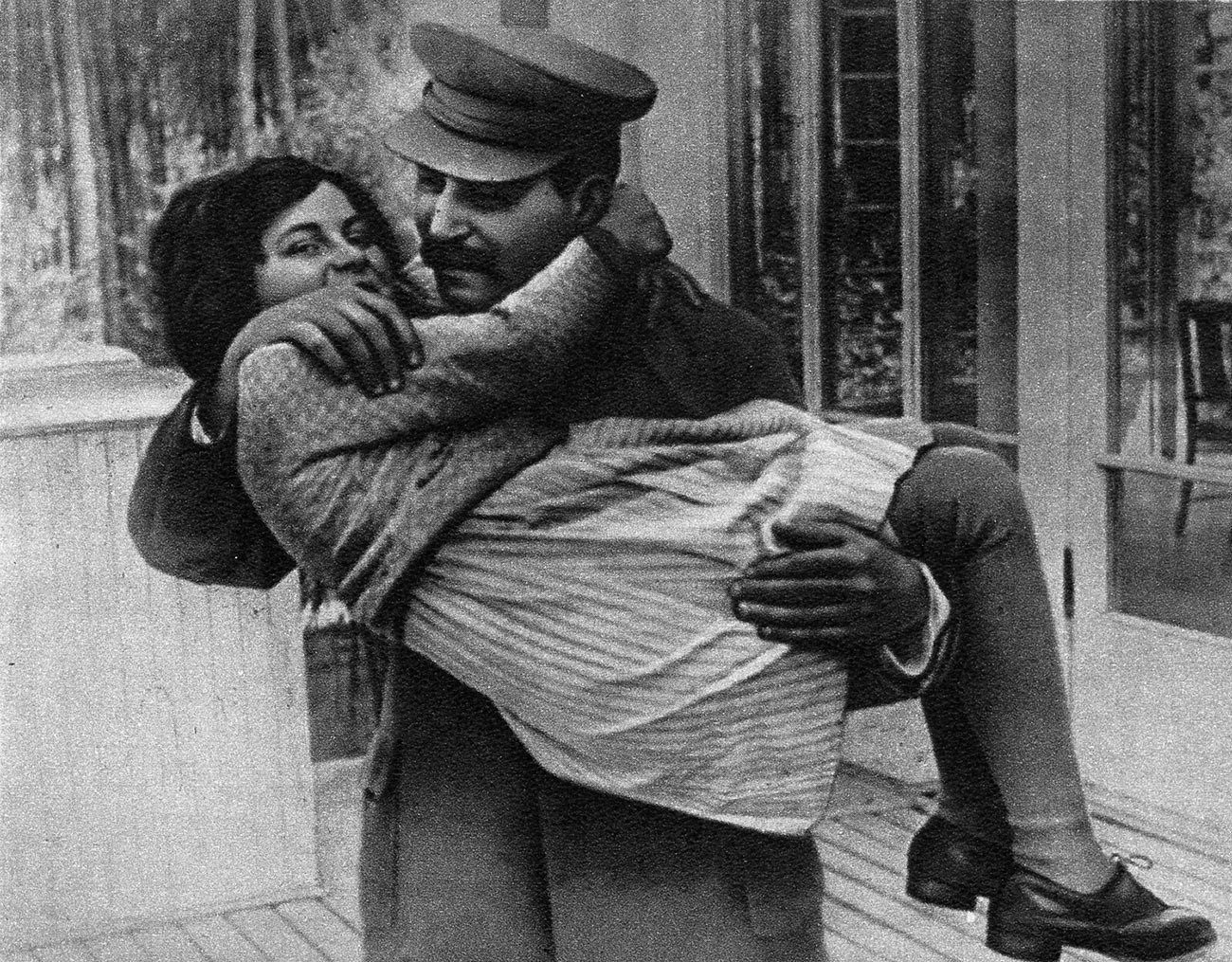 Joseph Stalin lifting his daughter Svetlana up with his both arms