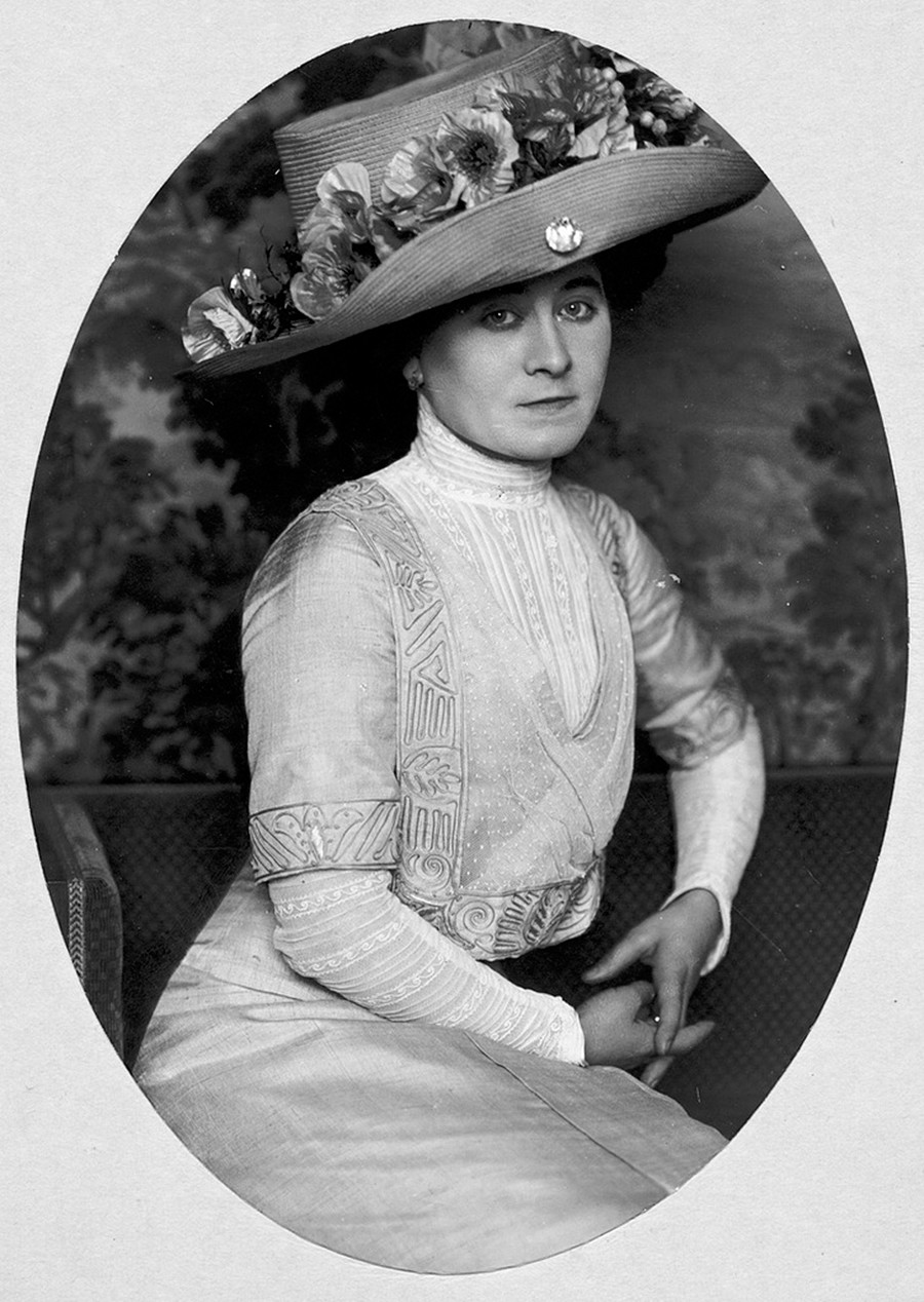 Potret seorang perempuan mengenakan topi.