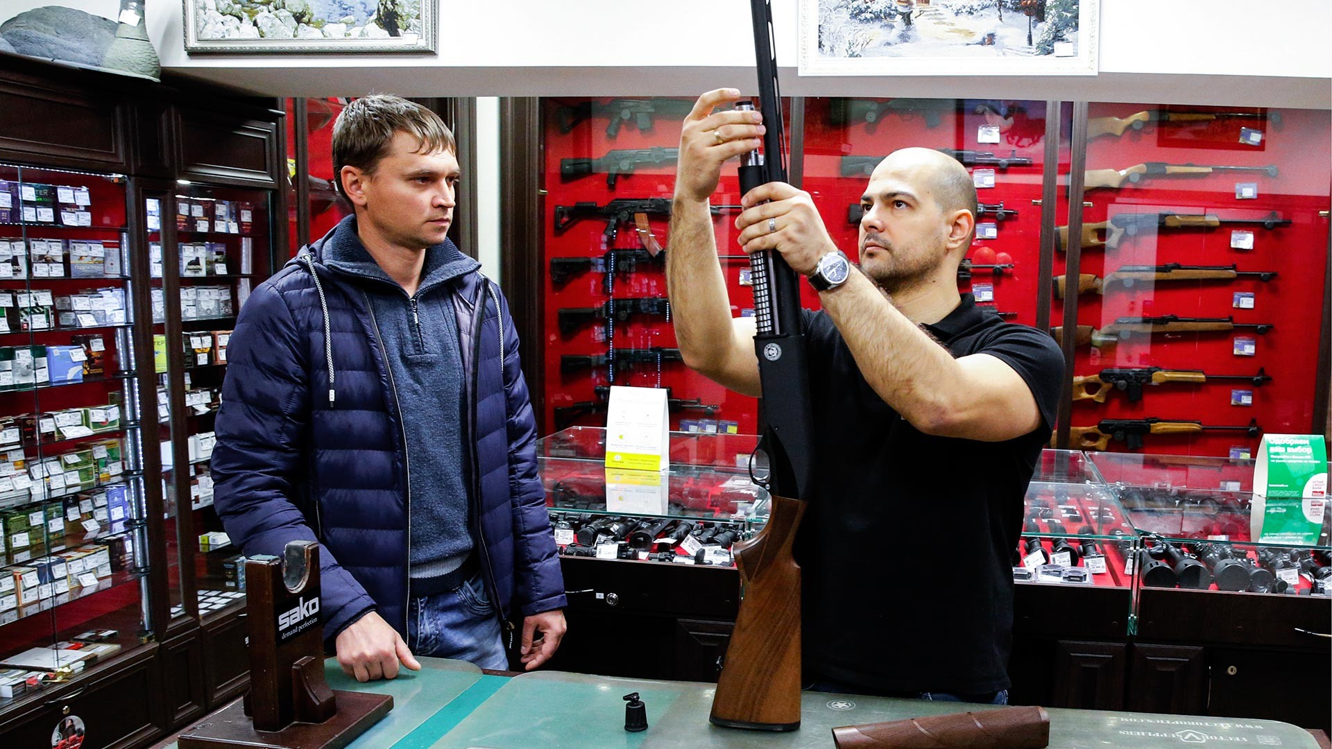 Penjual menunjukkan senapan semi otomatis HUGLU GX 512 di toko senjata Tiger.
