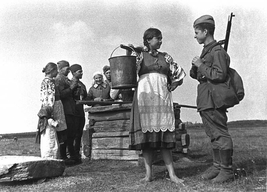 井戸のそばに立つ少女と兵士