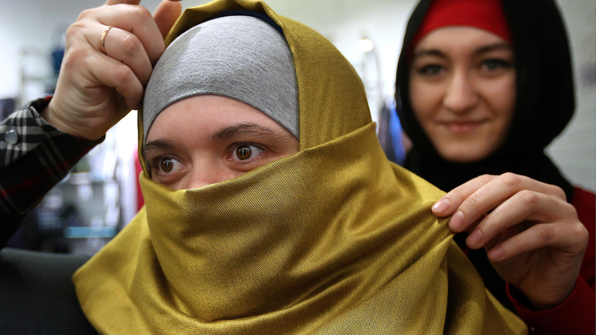 Seorang perempuan tengah memilih jilbab di pusat perbelanjaan Moskow.
