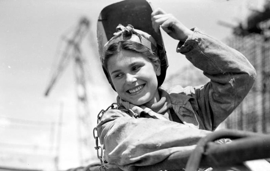 A female welder laughing  