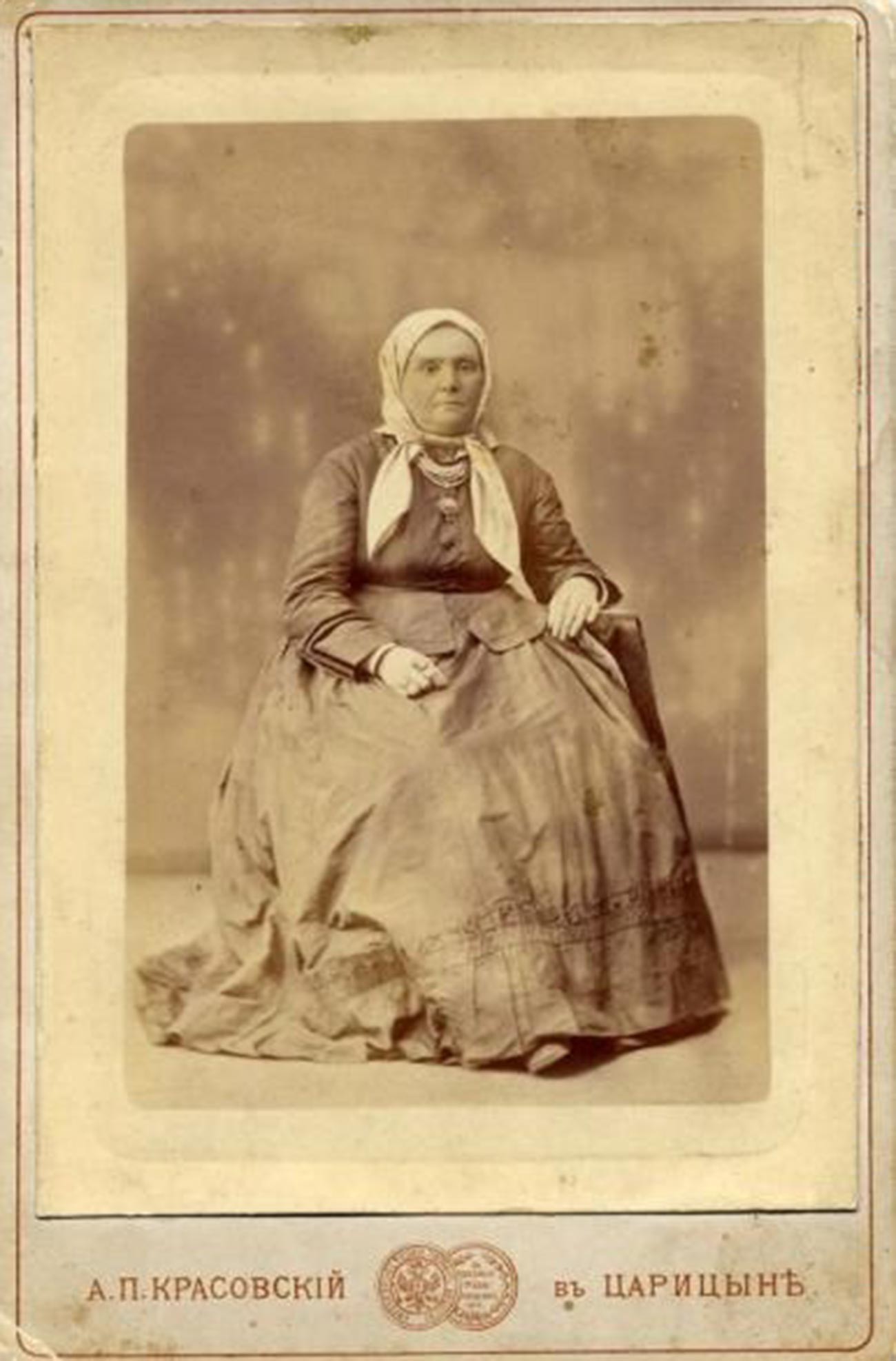 スカーフをかぶってポーズを取る老女。1870年代