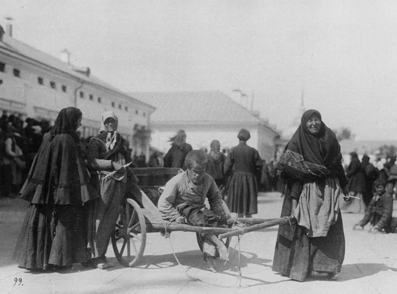 Женщина-крестьянка везет на тележке больного молодого человека у Саровского монастыря, 1903