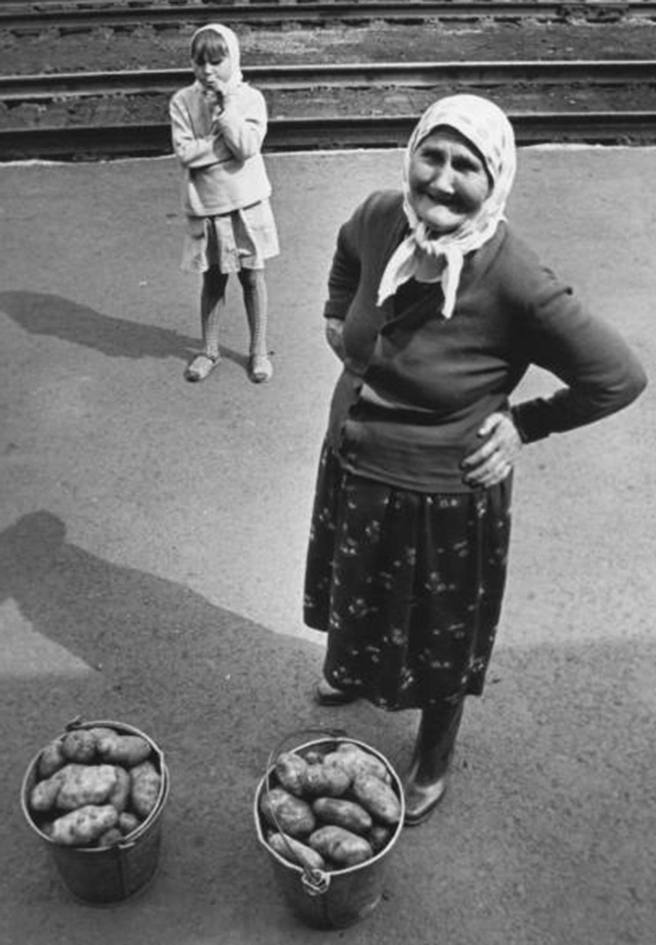 Seorang perempuan tua menjual kentang di stasiun kereta api, di suatu tempat di Pegunungan Ural, 1974.