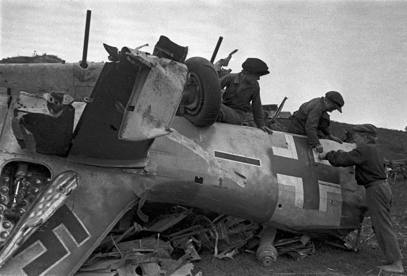 Des garçons découvrant un avion de chasse allemand Messerschmitt, abattu durant la bataille de Koursk.