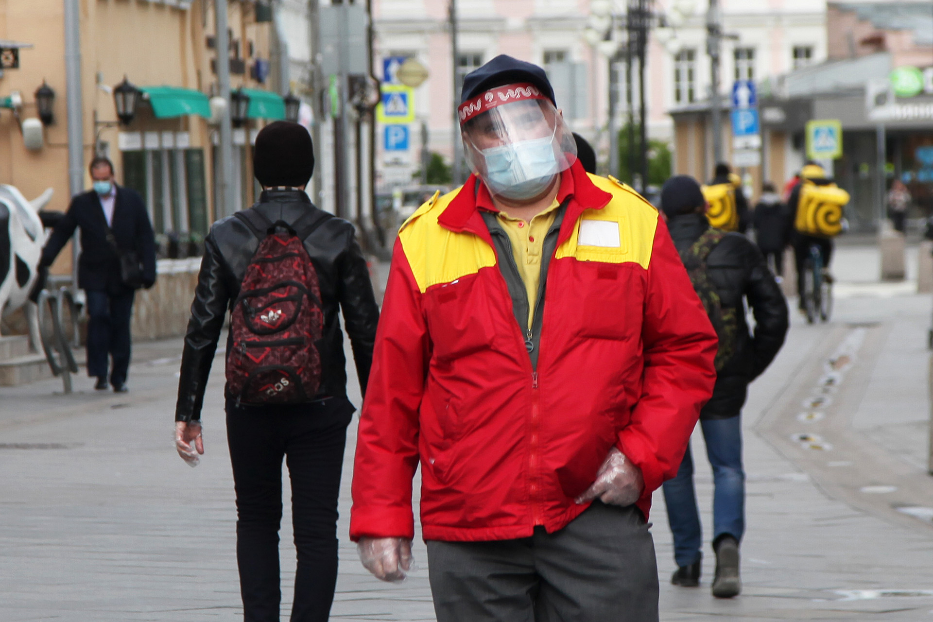 Seorang pria mengenakan pelindung wajah saat berjalan di Klimentovskiy Pereulok, tidak jauh dari Stasiun Metro Tretyakovskaya.