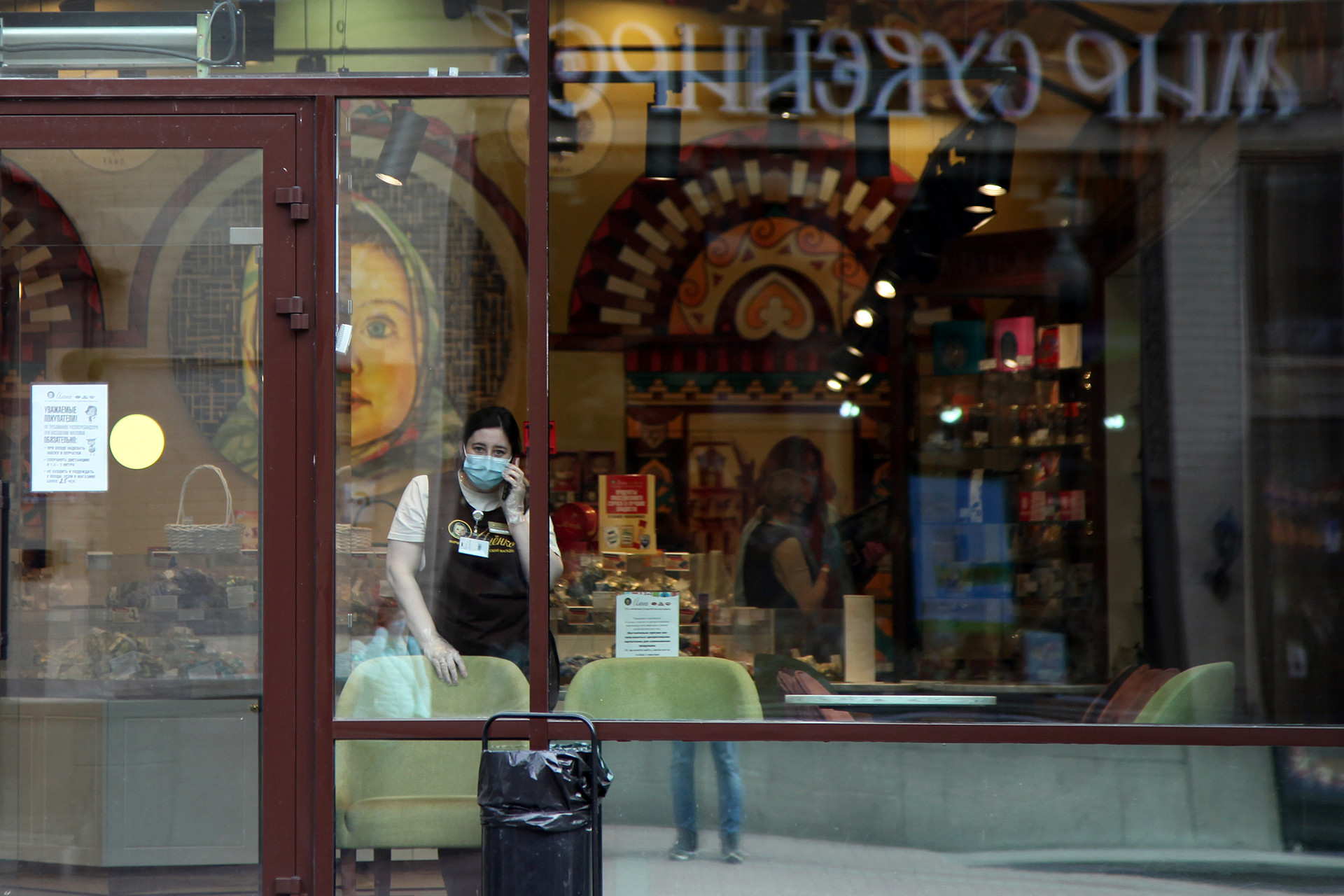 Seorang pekerja toko sedang berbicara di telepon di sebuah toko cokelat khas Rusia Alyonka, yang sepi pembeli di daerah Arbatskaya Ulitsa.